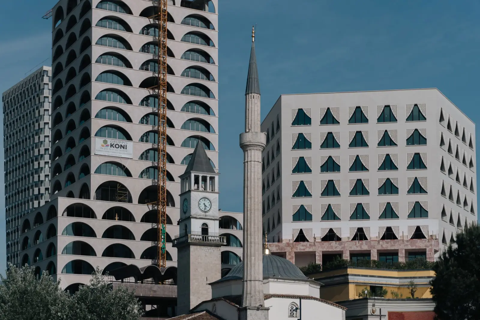 Një kullë sahati dhe një minare mes ndërtesave moderne në Tiranë